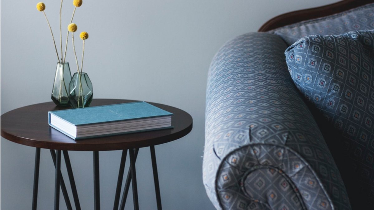 A cozy armchair with a side table and a book